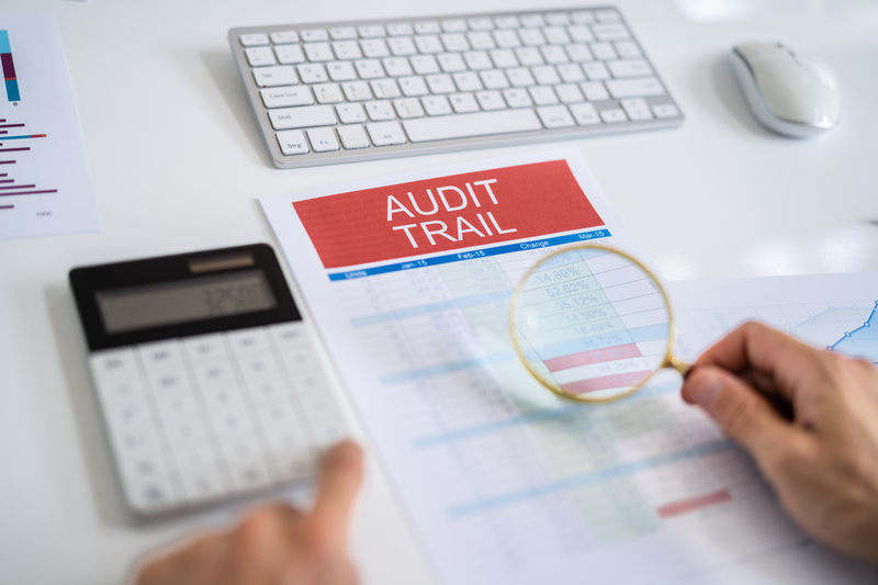 Image of someone examining an audit trail through financial documents