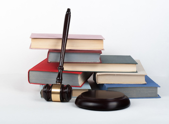 A gavel sitting next to regulation books