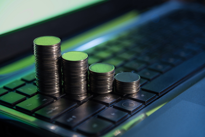 Coins stacked on an open laptop computer connected to the internet.